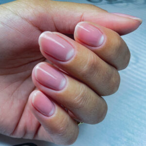 Manucure naturelle rosée avec finition brillante et préparation parfaite de l’ongle naturel.