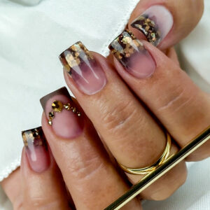 Pose gel forme carré avec dégradé marron fumé, encapsulation de paillettes dorées et strass délicats en finition.